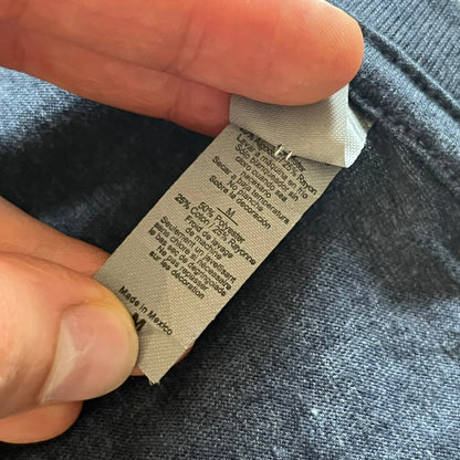 Close-up of a clothing label on a garment with a hand holding it.