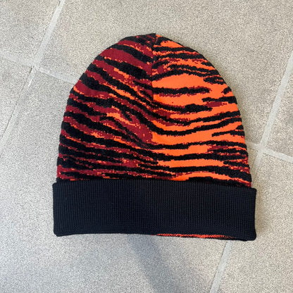 Kenzo x H&amp;M Orange Tiger Camo Beanie is a knit beanie from the 2016 collaboration. It features an all-over tiger camouflage pattern in red, orange, and dark red tones, woven directly into the fabric. The design is finished with a black cuff and can be worn either slouched or folded for a more traditional beanie fit.