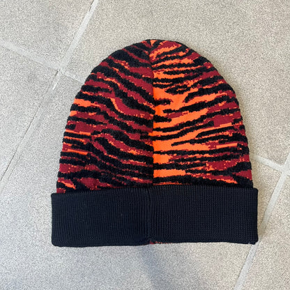 Kenzo x H&amp;M Orange Tiger Camo Beanie is a knit beanie from the 2016 collaboration. It features an all-over tiger camouflage pattern in red, orange, and dark red tones, woven directly into the fabric. The design is finished with a black cuff and can be worn either slouched or folded for a more traditional beanie fit.