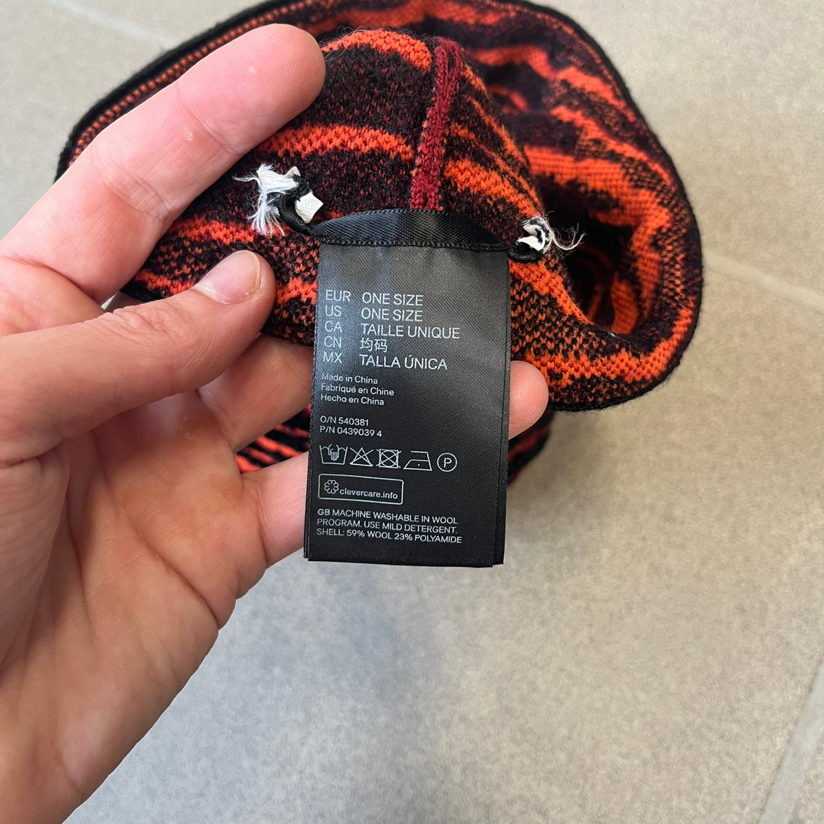 Kenzo x H&amp;M Orange Tiger Camo Beanie is a knit beanie from the 2016 collaboration. It features an all-over tiger camouflage pattern in red, orange, and dark red tones, woven directly into the fabric. The design is finished with a black cuff and can be worn either slouched or folded for a more traditional beanie fit.