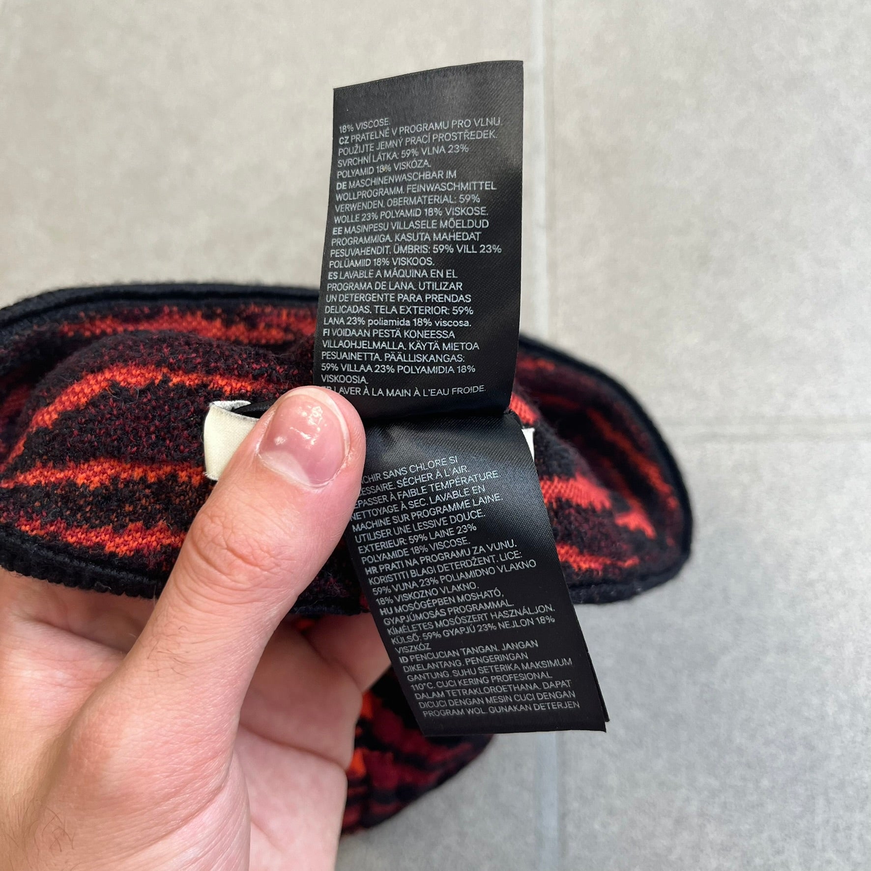 Kenzo x H&amp;M Orange Tiger Camo Beanie is a knit beanie from the 2016 collaboration. It features an all-over tiger camouflage pattern in red, orange, and dark red tones, woven directly into the fabric. The design is finished with a black cuff and can be worn either slouched or folded for a more traditional beanie fit.