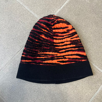 Kenzo x H&amp;M Orange Tiger Camo Beanie is a knit beanie from the 2016 collaboration. It features an all-over tiger camouflage pattern in red, orange, and dark red tones, woven directly into the fabric. This second version of the beanie is tighter and thicker, so the black cuff can't be folded.