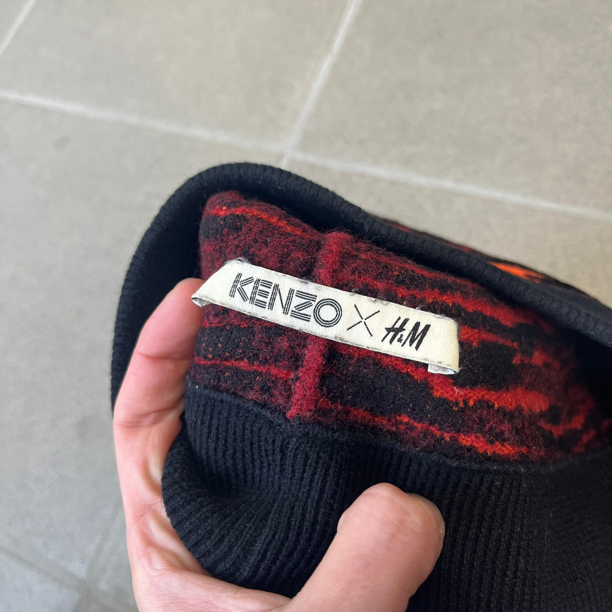 Kenzo x H&amp;M Orange Tiger Camo Beanie is a knit beanie from the 2016 collaboration. It features an all-over tiger camouflage pattern in red, orange, and dark red tones, woven directly into the fabric. This second version of the beanie is tighter and thicker, so the black cuff can't be folded.