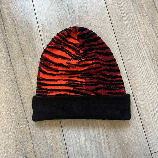 Kenzo x H&amp;M Orange Tiger Camo Beanie is a knit beanie from the 2016 collaboration. It features an all-over tiger camouflage pattern in red, orange, and dark red tones, woven directly into the fabric. The design is finished with a black cuff and can be worn either slouched or folded for a more traditional beanie fit.