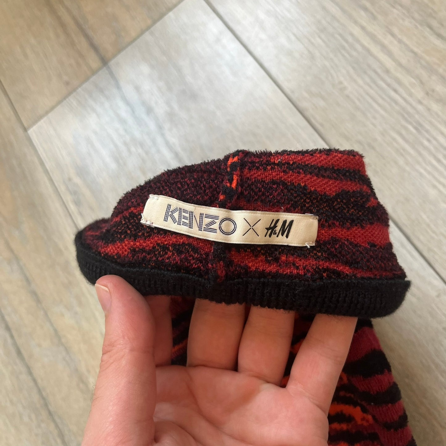 Kenzo x H&amp;M Orange Tiger Camo Beanie is a knit beanie from the 2016 collaboration. It features an all-over tiger camouflage pattern in red, orange, and dark red tones, woven directly into the fabric. The design is finished with a black cuff and can be worn either slouched or folded for a more traditional beanie fit.