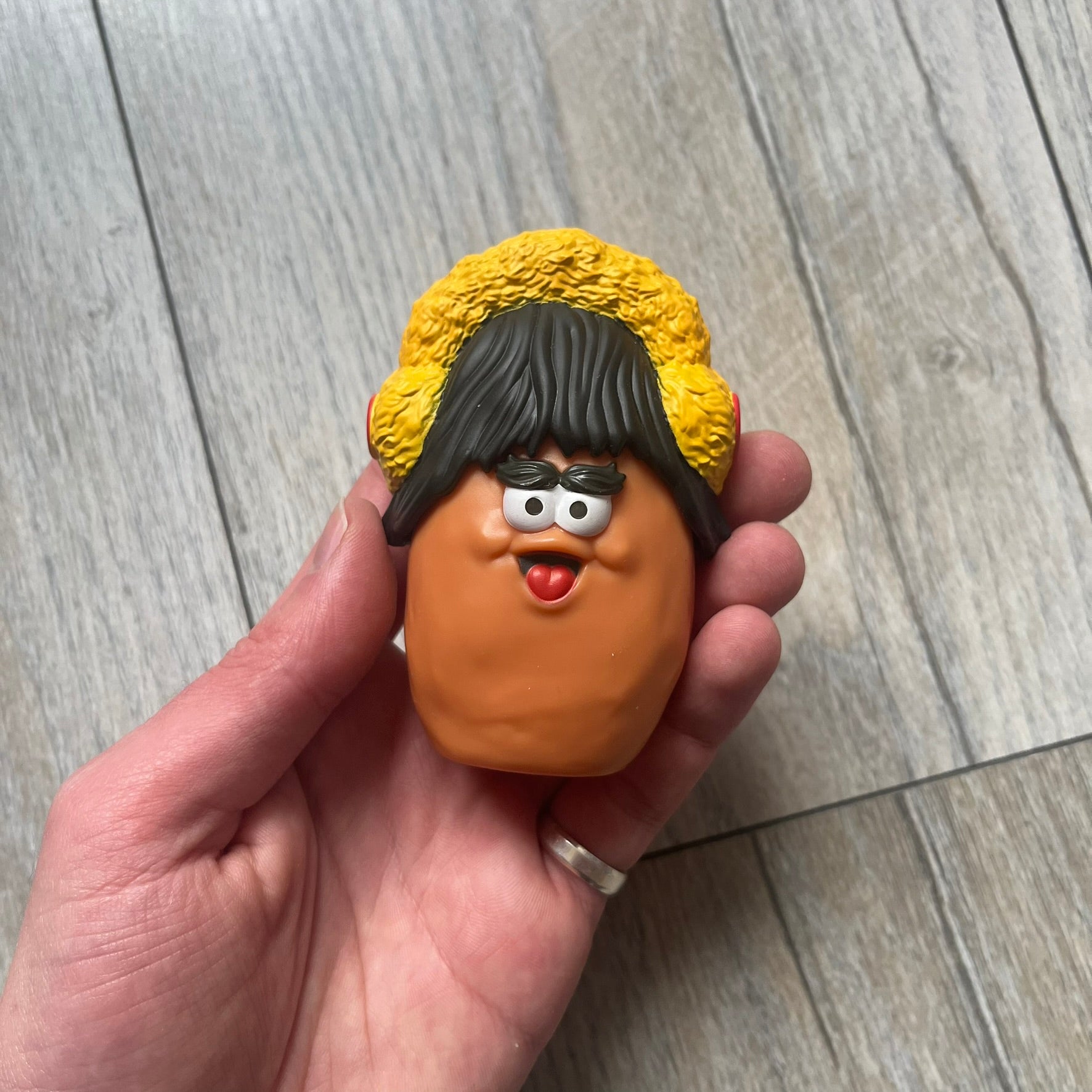 Kerwin Frost x McDonald’s McNugget Figure is a 2023 release from the Kerwin Frost x McDonald’s Nugget Buddies collaboration. The figure combines the Waffutu body with a Darla head, featuring a smiling McNugget character with long hair and yellow earmuffs.