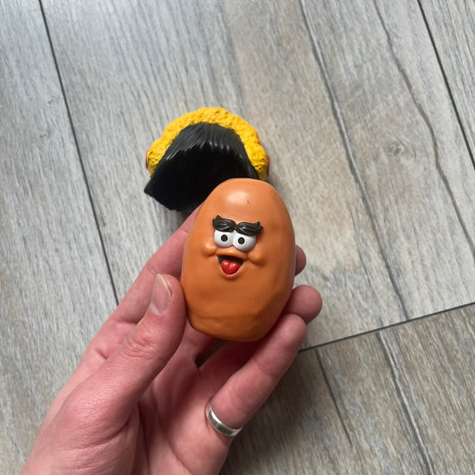 Kerwin Frost x McDonald’s McNugget Figure is a 2023 release from the Kerwin Frost x McDonald’s Nugget Buddies collaboration. The figure combines the Waffutu body with a Darla head, featuring a smiling McNugget character with long hair and yellow earmuffs.