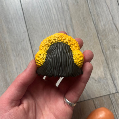 Kerwin Frost x McDonald’s McNugget Figure is a 2023 release from the Kerwin Frost x McDonald’s Nugget Buddies collaboration. The figure combines the Waffutu body with a Darla head, featuring a smiling McNugget character with long hair and yellow earmuffs.