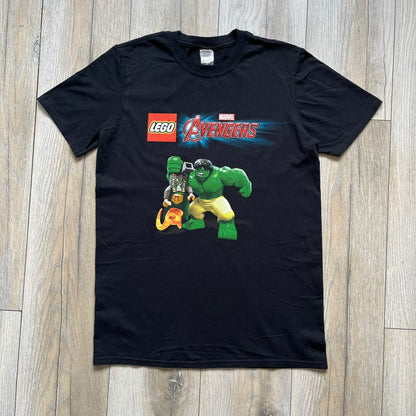 LEGO Avengers 2016 Promo Tee is a black T-shirt featuring a LEGO Marvel Avengers logo on the front. Below the logo is a graphic of LEGO Hulk holding Loki upside down. The shirt is made on a Gildan blank and includes 2016 LEGO and Marvel licensing inside the shirt.