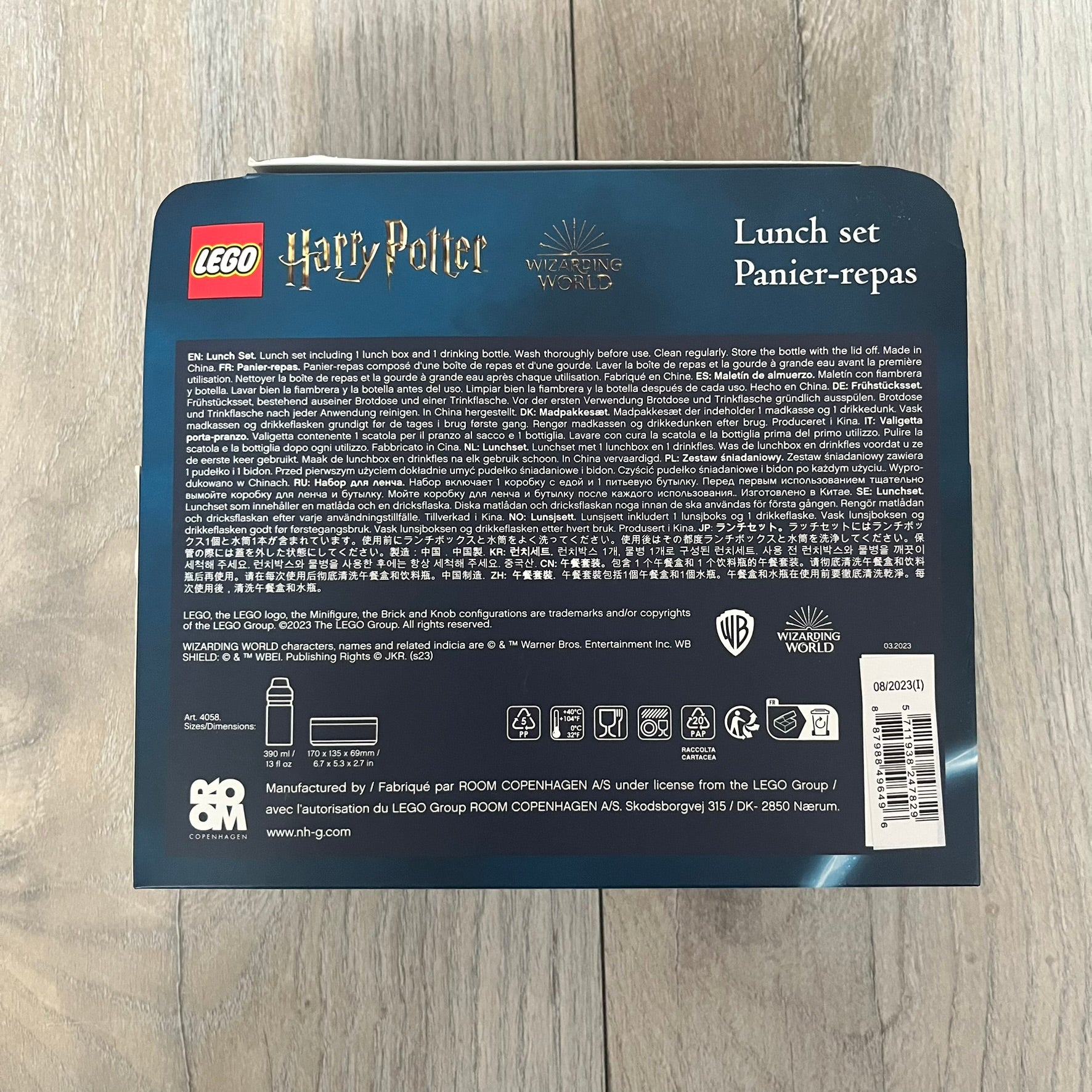 LEGO Harry Potter 2023 Hogwarts Lunch Set is a beige-themed lunch set designed for children aged 3 and up. It includes a polypropylene lunch box and a 390 mL drinking bottle with a silicone spout and hygiene cap. Both items feature illustrations of LEGO Harry Potter characters. The lunch box has easy-open clips, a movable internal divider for separating food, and a lid that can also be used as a plate. The set is designed for portability and everyday use.