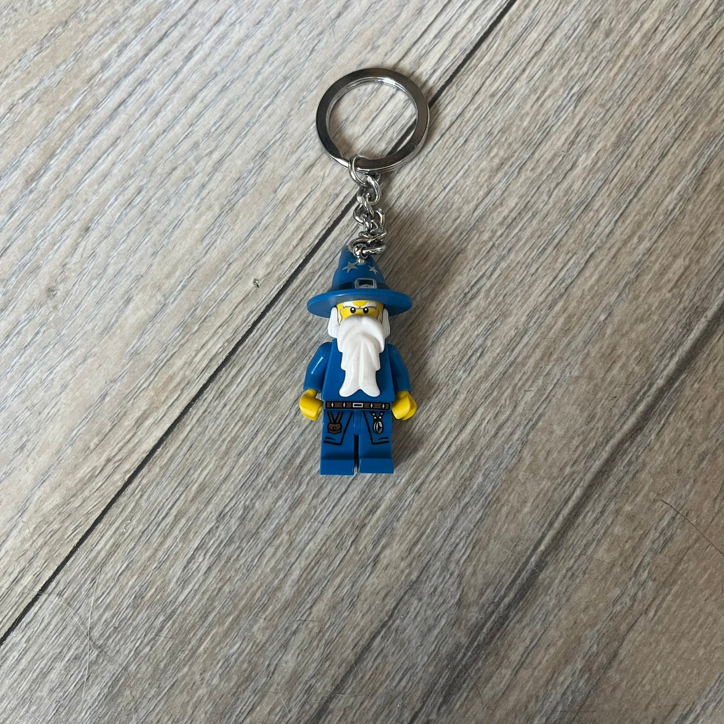LEGO Kingdoms 853088 Majisto Wizard Keychain is a 2011 release featuring a LEGO Kingdoms Wizard (Majisto) minifigure attached to a sturdy metal key chain. The minifigure is fixed to the chain and designed for use as a keychain or backpack accessory.