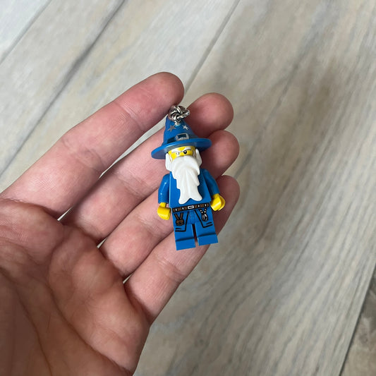 LEGO Kingdoms 853088 Majisto Wizard Keychain is a 2011 release featuring a LEGO Kingdoms Wizard (Majisto) minifigure attached to a sturdy metal key chain. The minifigure is fixed to the chain and designed for use as a keychain or backpack accessory.