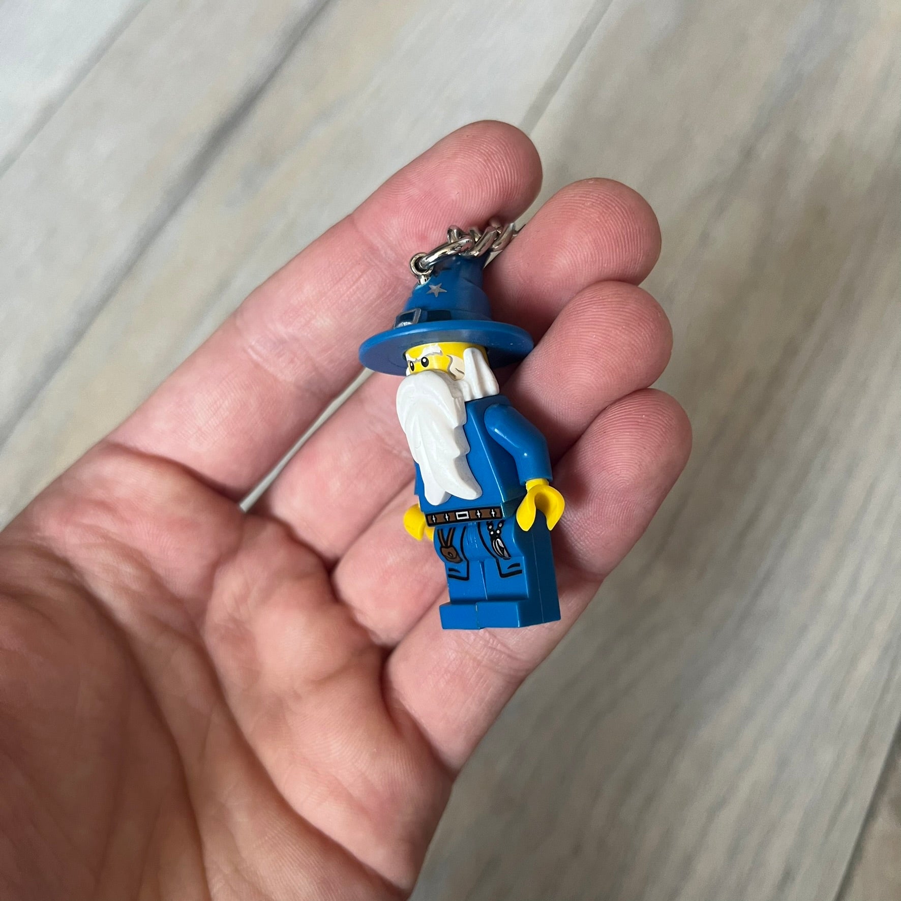 LEGO Kingdoms 853088 Majisto Wizard Keychain is a 2011 release featuring a LEGO Kingdoms Wizard (Majisto) minifigure attached to a sturdy metal key chain. The minifigure is fixed to the chain and designed for use as a keychain or backpack accessory.