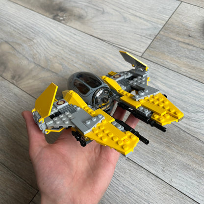 LEGO Star Wars 75038 Jedi Interceptor Set is a 2014 release featuring Anakin Skywalker’s yellow Eta-2 Actis-Class Interceptor. The set includes Anakin Skywalker minifigure with headset and lightsaber, along with an R2-D2 figure. The build features an opening cockpit, folding wing flaps, and dual spring-loaded shooters, measuring approximately 19 cm in length.