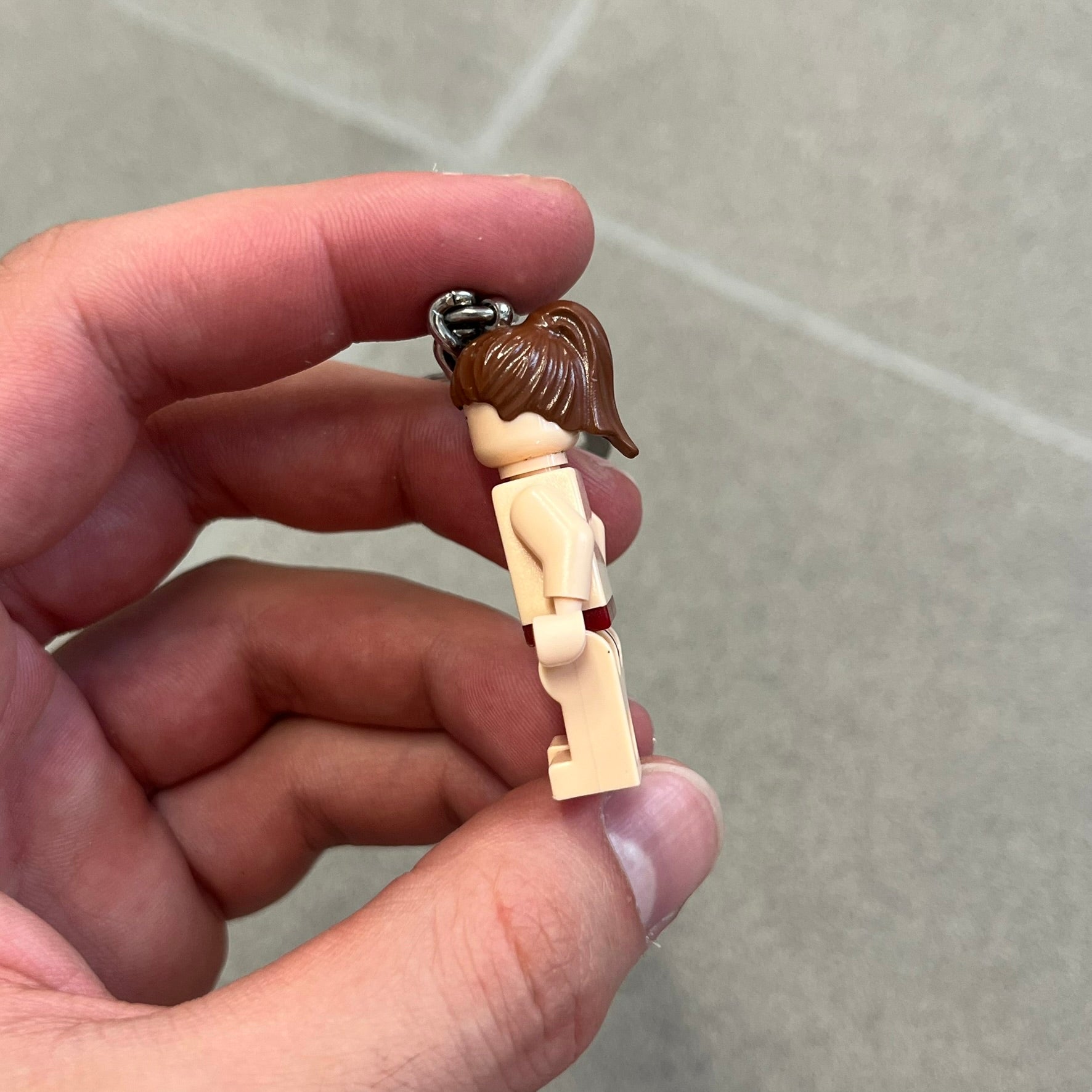 LEGO Star Wars 851938 Princess Leia Key Chain is a 2007 LEGO Gear accessory featuring a Princess Leia minifigure attached to a metal key ring and chain. The figure is permanently fixed to the chain and cannot be removed. The minifigure depicts Princess Leia in her bikini outfit from Jabba’s sail barge scene in Star Wars: Return of the Jedi.