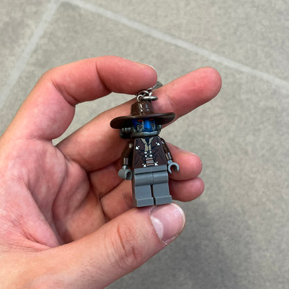 LEGO Star Wars 853127 Cad Bane Key Chain is a 2011 LEGO Gear accessory featuring a Cad Bane minifigure attached to a metal key ring and chain. The figure is permanently fixed to the chain and cannot be removed. The design depicts Cad Bane, the Duros bounty hunter from Star Wars: The Clone Wars, including his signature hat and outfit details.