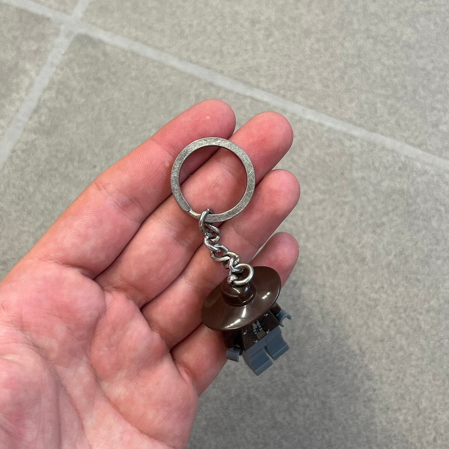 LEGO Star Wars 853127 Cad Bane Key Chain is a 2011 LEGO Gear accessory featuring a Cad Bane minifigure attached to a metal key ring and chain. The figure is permanently fixed to the chain and cannot be removed. The design depicts Cad Bane, the Duros bounty hunter from Star Wars: The Clone Wars, including his signature hat and outfit details.