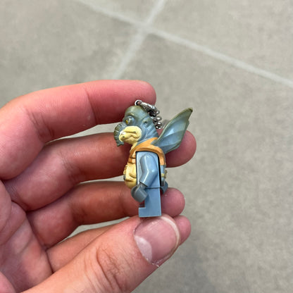 LEGO Star Wars 853413 Watto Key Chain is a 2012 LEGO Gear accessory featuring an authentic LEGO Watto minifigure attached to a metal key ring and chain. The Watto figure is permanently fixed to the chain and cannot be removed. The design represents Watto, the Toydarian junk dealer character from Star Wars: The Phantom Menace.