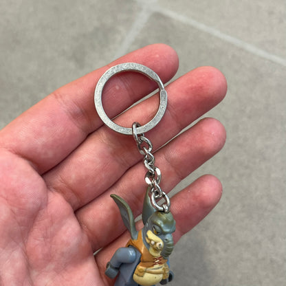 LEGO Star Wars 853413 Watto Key Chain is a 2012 LEGO Gear accessory featuring an authentic LEGO Watto minifigure attached to a metal key ring and chain. The Watto figure is permanently fixed to the chain and cannot be removed. The design represents Watto, the Toydarian junk dealer character from Star Wars: The Phantom Menace.