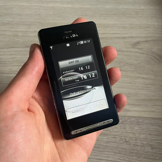 The LG Prada KE850, a groundbreaking collaboration between LG and Prada marked the world’s first capacitive touchscreen phone. Finished in sleek black with minimalist Prada aesthetics, it features media playback, Bluetooth, and expandable memory. Includes the full original Prada set: box, charger, cable, music device, manuals, and CD. Unlocked and functional for basic functions; for calling and texting you need your own SIM card.