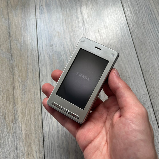 The LG Prada KE850, a groundbreaking collaboration between LG and Prada marked the world’s first capacitive touchscreen phone. Finished in silver and gray with minimalist Prada aesthetics, it features media playback, Bluetooth, and expandable memory. Sim locked.