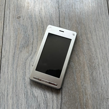 The LG Prada KE850, a groundbreaking collaboration between LG and Prada marked the world’s first capacitive touchscreen phone. Finished in silver and gray with minimalist Prada aesthetics, it features media playback, Bluetooth, and expandable memory. Sim locked.