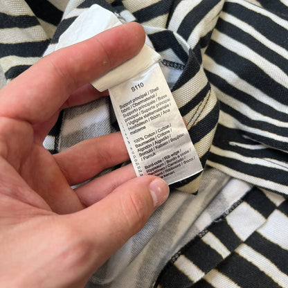  Lacoste x National Geographic AW20 Zebra Polo features an all-over white and black zebra print pattern across the fabric. The polo has black collar and sleeve hems, with a chest patch featuring the Lacoste crocodile logo in matching pattern colors.