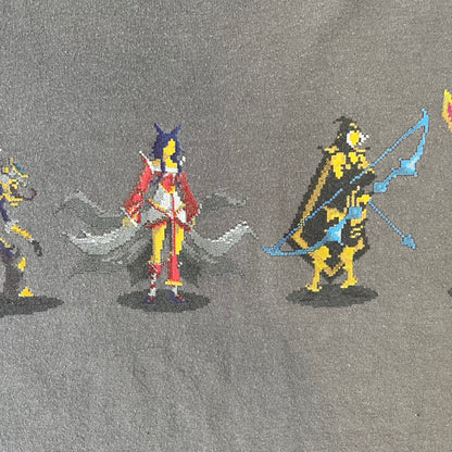 League of Legends 2013 Pixel Team Gray Tee is a gray T-shirt featuring a full five-champion team (Garen, Master Yi, Ahri, Ashe, and Kayle) rendered in pixel art style on the front. The upper back shows League main Logo. Licensed 2013 neck tag with the old Riot Games logo.