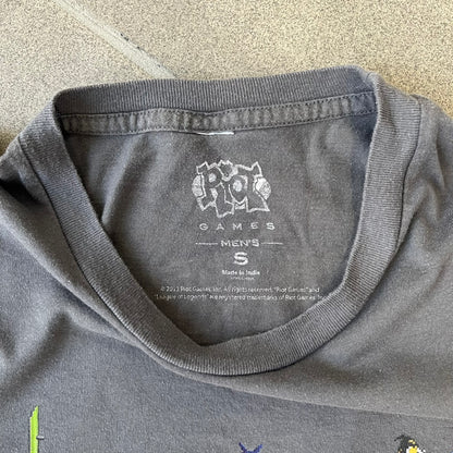 League of Legends 2013 Pixel Team Gray Tee is a gray T-shirt featuring a full five-champion team (Garen, Master Yi, Ahri, Ashe, and Kayle) rendered in pixel art style on the front. The upper back shows League main Logo. Licensed 2013 neck tag with the old Riot Games logo.