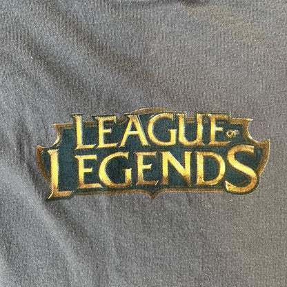 League of Legends 2013 Pixel Team Gray Tee is a gray T-shirt featuring a full five-champion team (Garen, Master Yi, Ahri, Ashe, and Kayle) rendered in pixel art style on the front. The upper back shows League main Logo. Licensed 2013 neck tag with the old Riot Games logo.