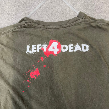 Left 4 Dead 2009 Infection Warning Tee features a khaki T-shirt with a distressed poster-style graphic on the front. The graphic has red “Infection Warning” text, instructions on what to do when infected, an emergency hotline number, and scribbled details. A Left 4 Dead logo and small 2009 Valve licensing appear underneath. The upper back features a Left 4 Dead logo with a blood splatter graphic.