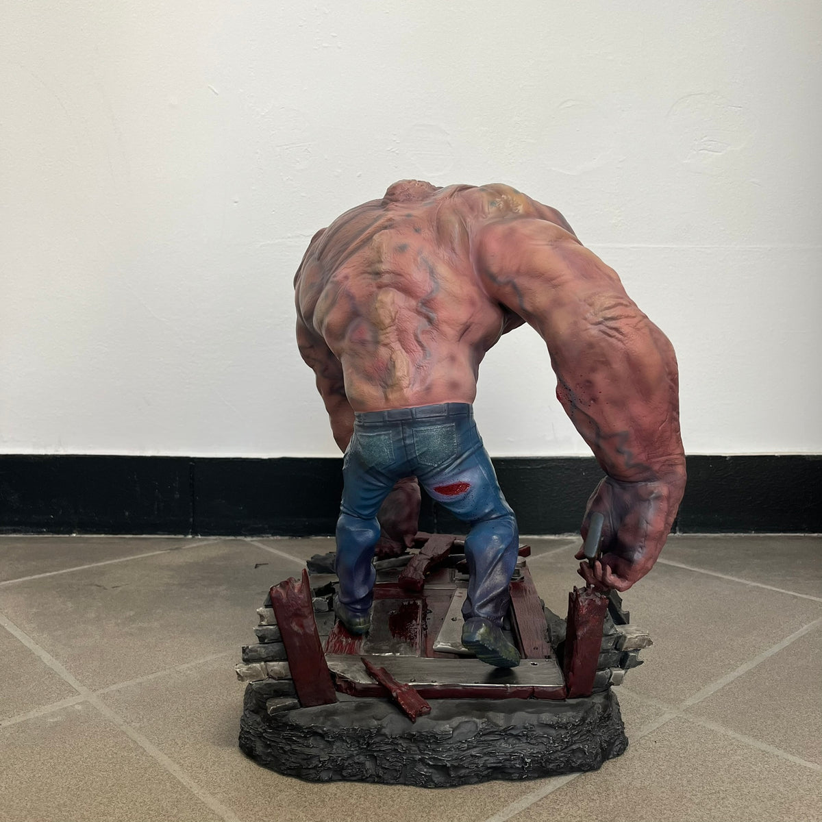 Left 4 Dead 2: Tank 2011 Exclusive Gaming Heads Statue is a limited edition poly-stone collectible based on the Tank character from Left 4 Dead 2. The statue is hand finished and hand painted, depicting the Tank smashing through a reinforced door with glow-in-the-dark painted eyes. It measures approximately 15 inches tall including the base and was limited to 300 pieces worldwide. This exclusive version comes with additional to scale Pump Shotgun that wasn't added in the standard edition. This piece is numb