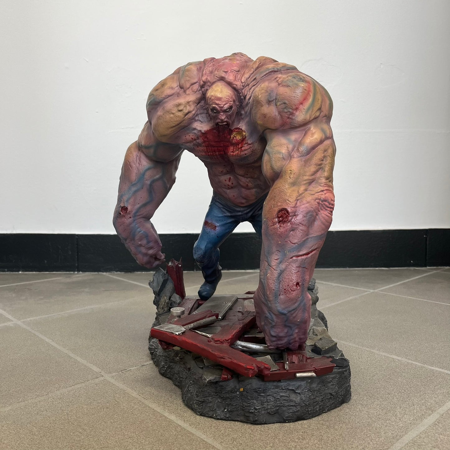Left 4 Dead 2 Tank 2011 Gaming Heads Statue is a limited edition poly-stone collectible based on the Tank character from Left 4 Dead 2. The statue is hand finished and hand painted, depicting the Tank smashing through a reinforced door with glow-in-the-dark painted eyes. It measures approximately 15 inches tall including the base and was limited to 750 pieces worldwide. This piece is number 224 and comes with the original shipping box, styrofoam packaging, colored box, and identification/validation card.
