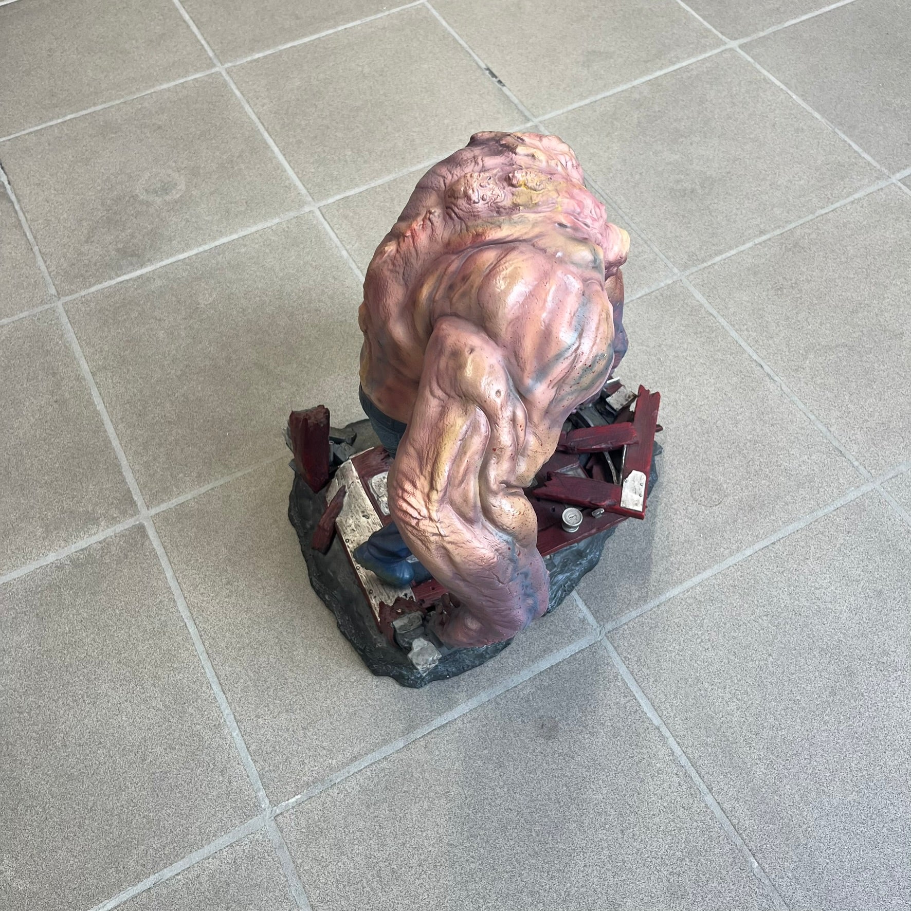 Left 4 Dead 2 Tank 2011 Gaming Heads Statue is a limited edition poly-stone collectible based on the Tank character from Left 4 Dead 2. The statue is hand finished and hand painted, depicting the Tank smashing through a reinforced door with glow-in-the-dark painted eyes. It measures approximately 15 inches tall including the base and was limited to 750 pieces worldwide. This piece is number 224 and comes with the original shipping box, styrofoam packaging, colored box, and identification/validation card.
