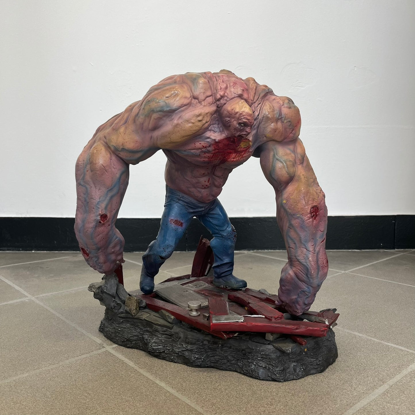 Left 4 Dead 2 Tank 2011 Gaming Heads Statue is a limited edition poly-stone collectible based on the Tank character from Left 4 Dead 2. The statue is hand finished and hand painted, depicting the Tank smashing through a reinforced door with glow-in-the-dark painted eyes. It measures approximately 15 inches tall including the base and was limited to 750 pieces worldwide. This piece is number 224 and comes with the original shipping box, styrofoam packaging, colored box, and identification/validation card.
