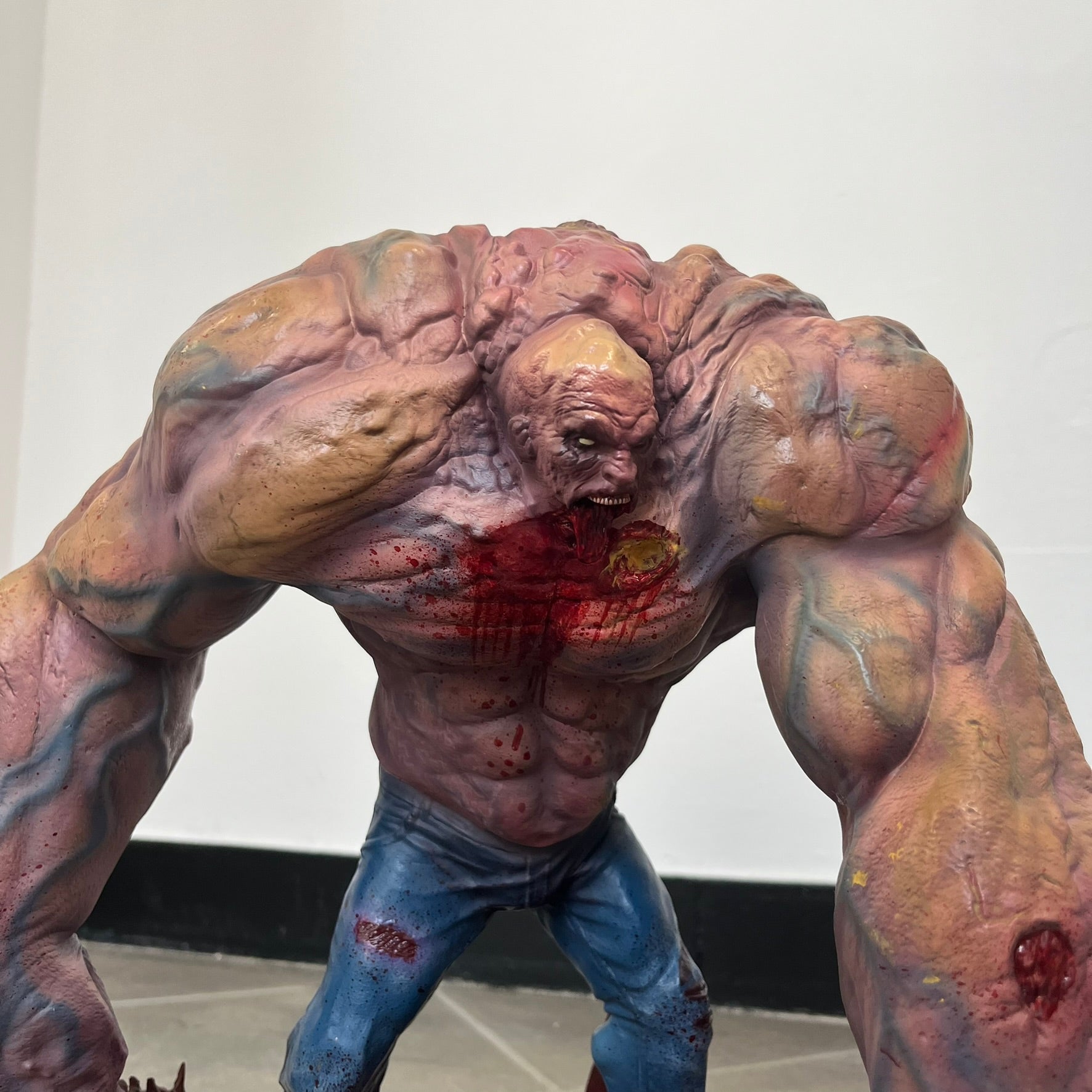 Left 4 Dead 2 Tank 2011 Gaming Heads Statue is a limited edition poly-stone collectible based on the Tank character from Left 4 Dead 2. The statue is hand finished and hand painted, depicting the Tank smashing through a reinforced door with glow-in-the-dark painted eyes. It measures approximately 15 inches tall including the base and was limited to 750 pieces worldwide. This piece is number 224 and comes with the original shipping box, styrofoam packaging, colored box, and identification/validation card.

