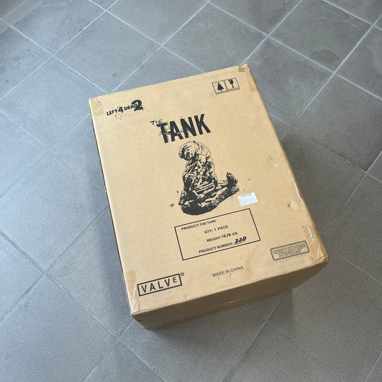 Left 4 Dead 2 Tank 2011 Gaming Heads Statue is a limited edition poly-stone collectible based on the Tank character from Left 4 Dead 2. The statue is hand finished and hand painted, depicting the Tank smashing through a reinforced door with glow-in-the-dark painted eyes. It measures approximately 15 inches tall including the base and was limited to 750 pieces worldwide. This piece is number 224 and comes with the original shipping box, styrofoam packaging, colored box, and identification/validation card.

