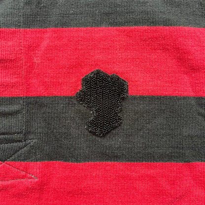 LEGO 2000 Black &amp; Red Rugby Shirt is a black and red striped long-sleeve rugby shirt with a cream/white collar. The chest includes a black Velcro patch panel without an attached patch, and a small LEGO tag is placed on one of the sleeves. The shirt has an official LEGO 2000 licensed neck tag.