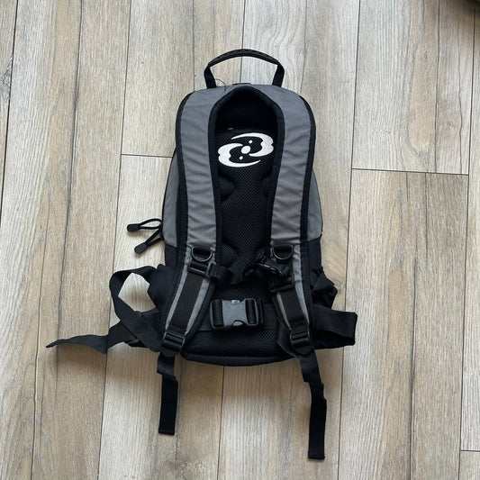 Lego Bionicle 2000s Matoran Alphabet Backpack is a backpack featuring a front design spelling “Bionicle” using the Matoran alphabet. The bag includes two front exterior pockets, a main compartment with three internal pockets, and a top media port for headphones. Additional details include padded and vented back panel, adjustable shoulder straps with chest connector and waist strap, top handle, and elastic cross straps on the front for extra storage.
