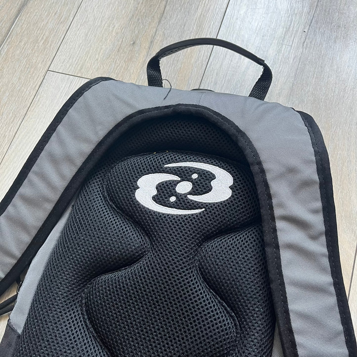 Lego Bionicle 2000s Matoran Alphabet Backpack is a backpack featuring a front design spelling “Bionicle” using the Matoran alphabet. The bag includes two front exterior pockets, a main compartment with three internal pockets, and a top media port for headphones. Additional details include padded and vented back panel, adjustable shoulder straps with chest connector and waist strap, top handle, and elastic cross straps on the front for extra storage.
