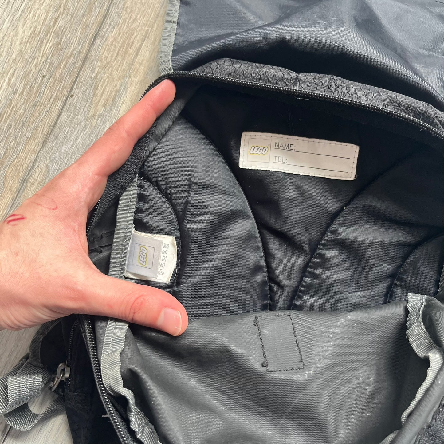 LEGO Bionicle 2009 Small Logo Backpack is a black backpack featuring a large white Bionicle logo on the lower front. The top flap section has a red all-over print with Bionicle characters and a LEGO logo patch. The interior includes a LEGO 2009 licensed tag.