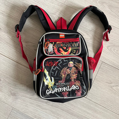 Lego Bionicle 2010 Glatorian Gresh Backpack made by Class Investment in 2010, featuring a front pocket with an embroidered Glatorian Ackar figure and text. The top pocket includes both Bionicle and LEGO logos, along with custom rubber zipper pulls. Finished with two side bottle pockets and additional Bionicle logo details, making it a great rare collectible for fans of the series.