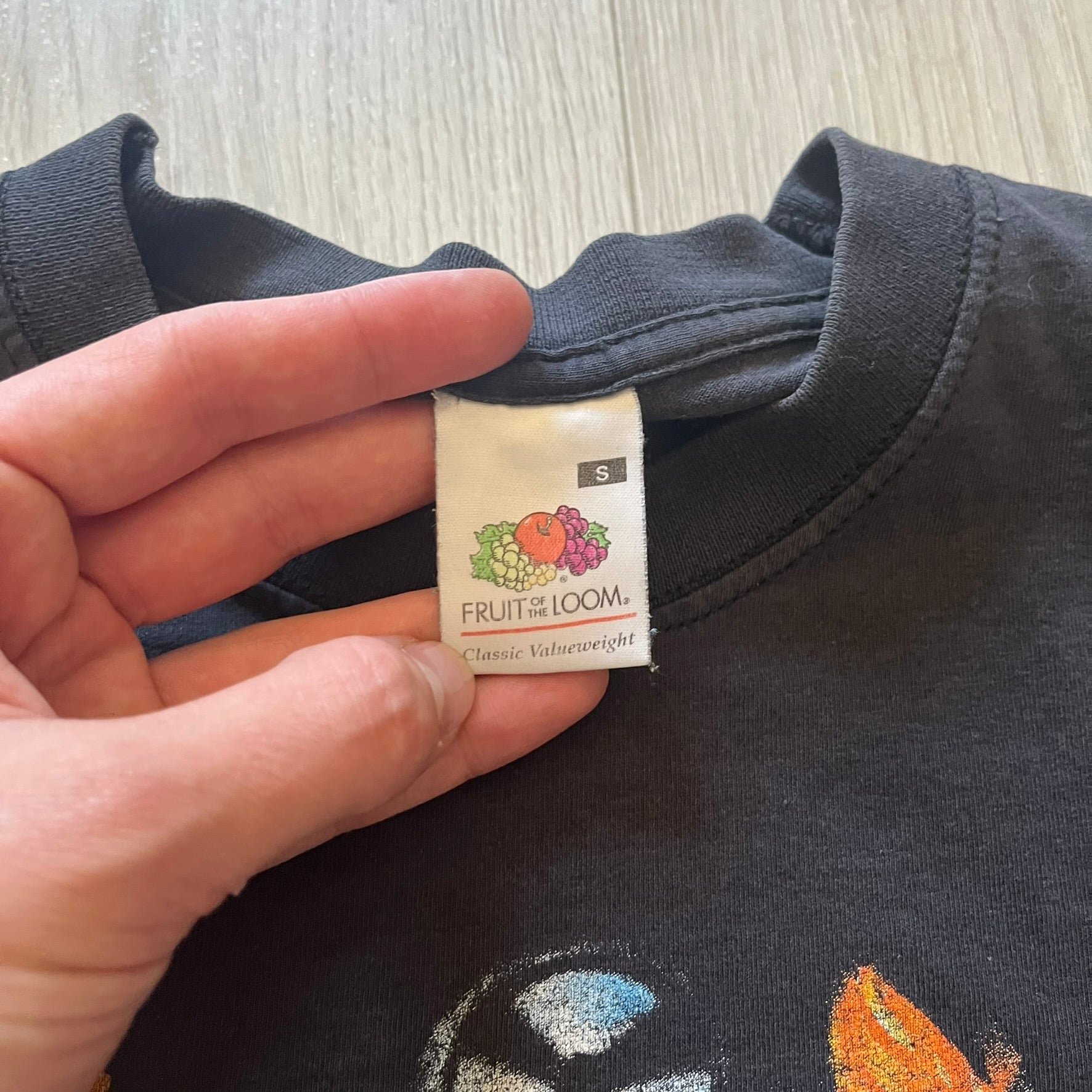 Rare 2000s Lego Bionicle T-shirt showcasing Toa Hordika Vakama from the 2005 set. Features the glowing Bionicle logo under the Binicle, small Lego branding and a naturally sunfaded black wash. A collectible tee that perfectly captures early-2000s nostalgia.