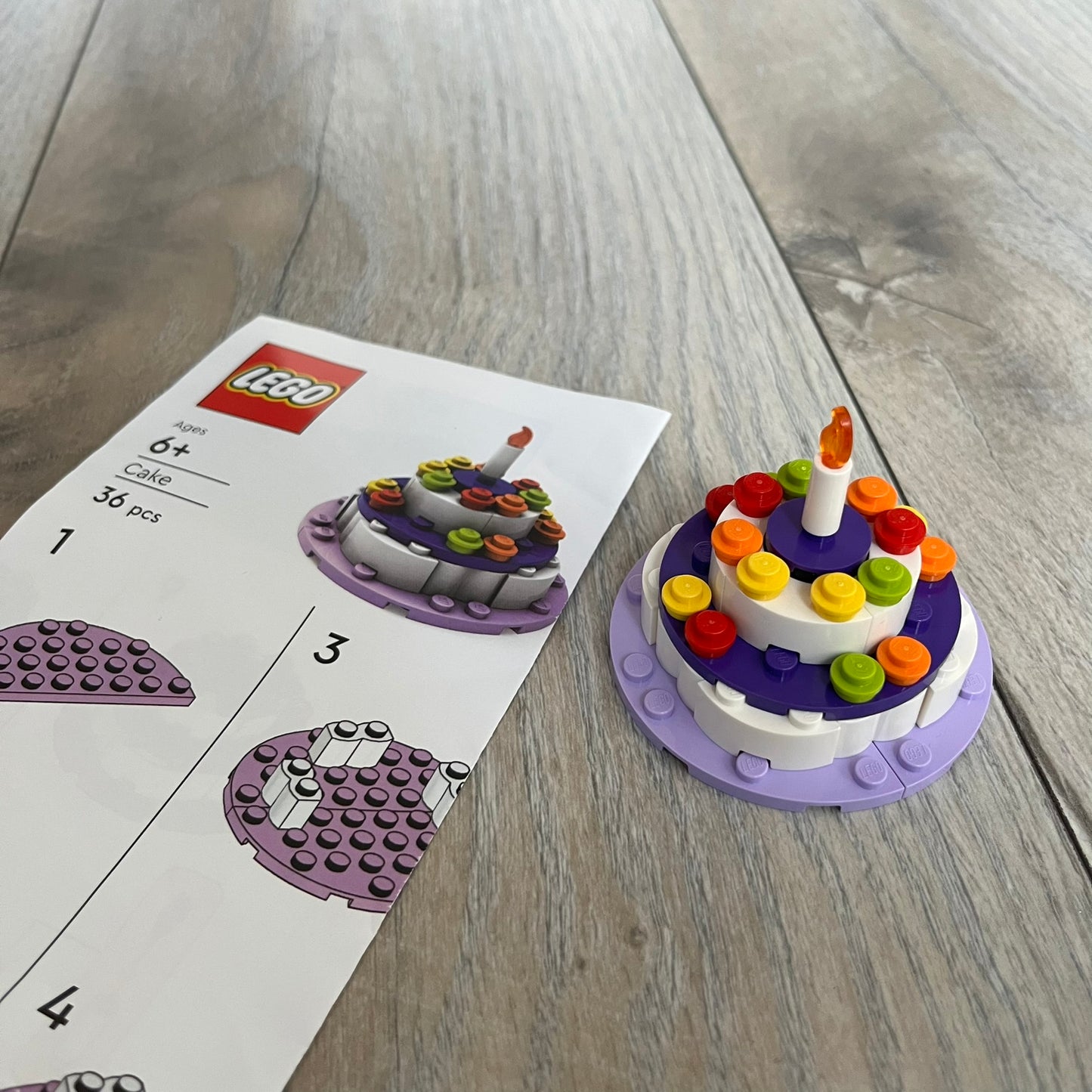 LEGO Cake Make and Take Build is a limited promotional LEGO set distributed as an exclusive “make & take” event and not available for retail purchase. The model features a small white and purple cake-style build with multicolor dot detailing and a single candle element on top.