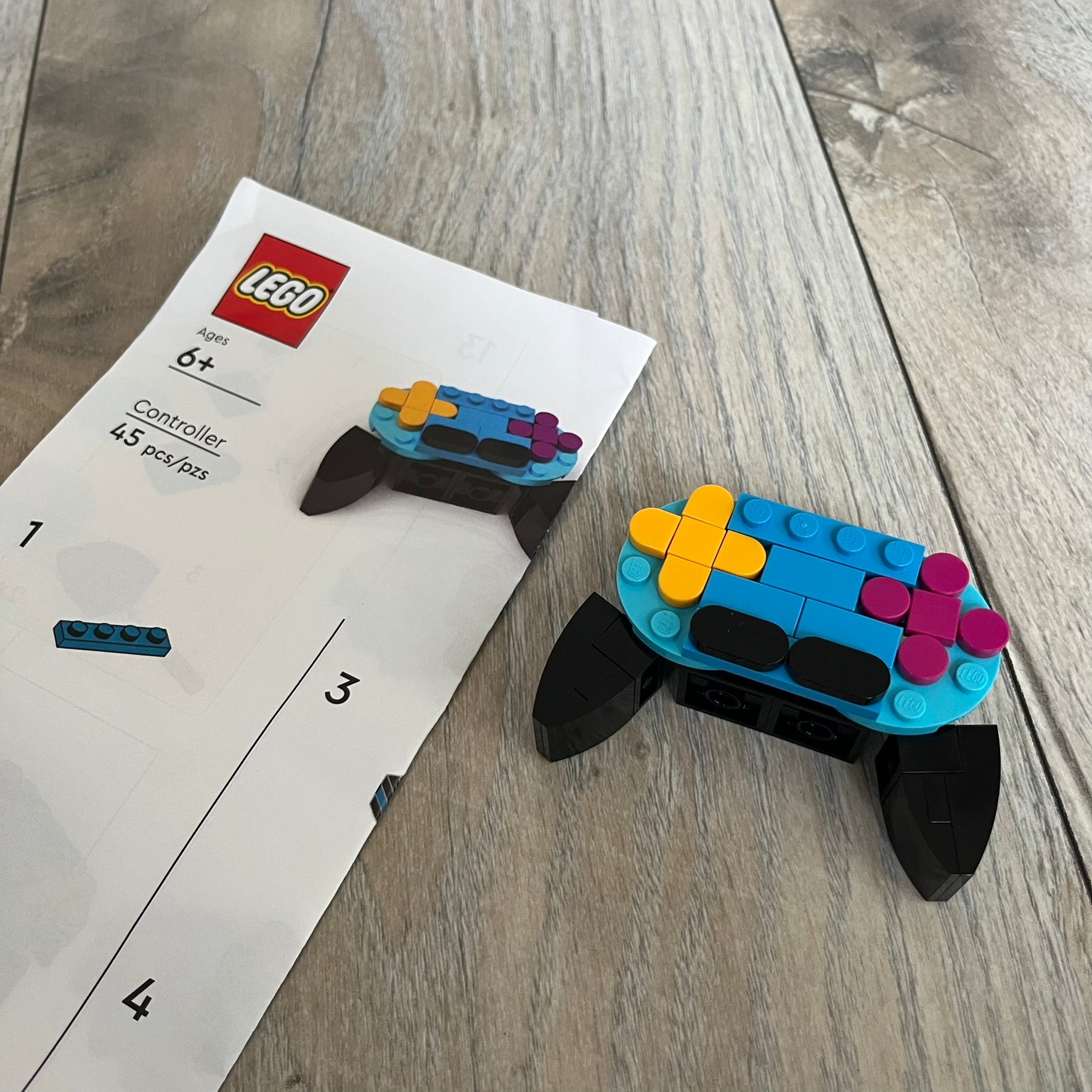 LEGO Controller Make and Take Build is a limited promotional LEGO set distributed as an exclusive “make & take” event and not available for retail purchase. The model features a small controller build in blue and black, with yellow and pink button elements.