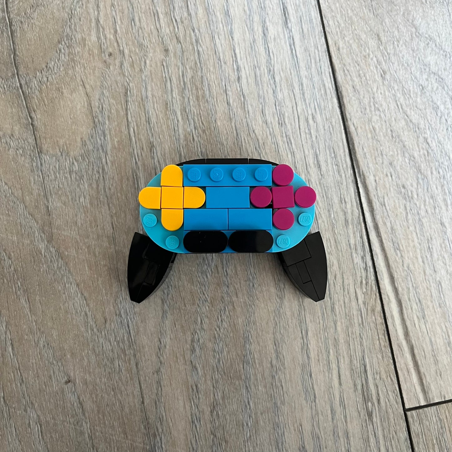 LEGO Controller Make and Take Build is a limited promotional LEGO set distributed as an exclusive “make & take” event and not available for retail purchase. The model features a small controller build in blue and black, with yellow and pink button elements.
