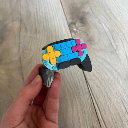 LEGO Controller Make and Take Build is a limited promotional LEGO set distributed as an exclusive “make & take” event and not available for retail purchase. The model features a small controller build in blue and black, with yellow and pink button elements.