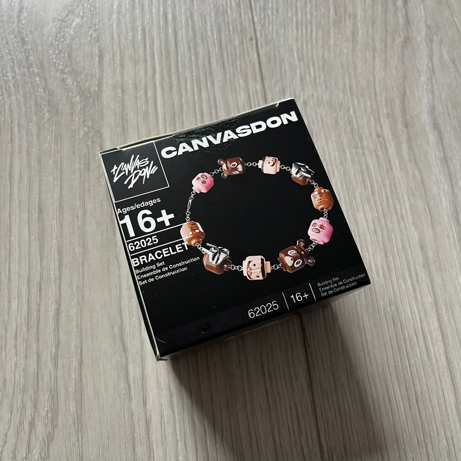 Lego Graduation Brick Bracelet featuring ten brown Lego bear heads from Kanye West’s Graduation era, set on a thin silver bracelet. The heads are standard Lego size and the piece comes in a custom-designed display box. Made by TheCanvasDon.