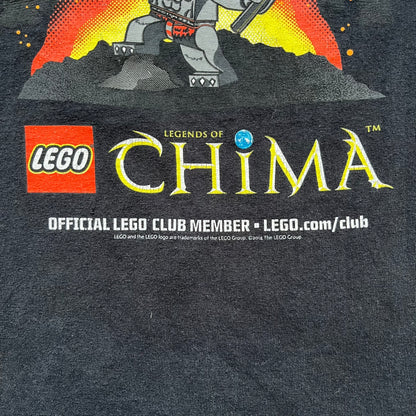 Lego Legends of Chima 2014 Black Tee is a black T-shirt made on a Gildan Ultra Cotton blank. The front features Winzar holding a torch with a large red character behind him and additional faded grey characters in the background. Below the graphic are the Lego Legends of Chima logo, “Official Lego Club Member” text, website link, and small 2014 licensing print.