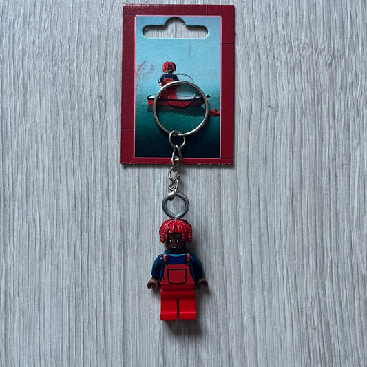 Lego Lil Yachty 'Lil Block' keychain featuring a custom Lego figure of Lil Yachty with red overalls and 3d red dreads. The figure is attached to a Lego-style recreation of the 2016 'Lil Boat' album cover, reimagined in brick graphics. A playful and creative collectible that merges music culture with fan-made Lego artistry, made by TheCanvasDon.